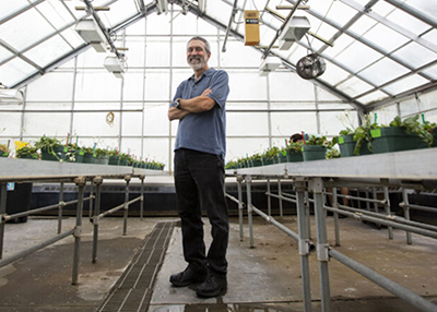 Jeff Conner standing in a greenhouose on campus.
