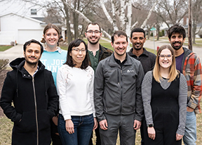 A group photo of Berkley Walker and his lab members outside of the Plant Biology Building on campus.